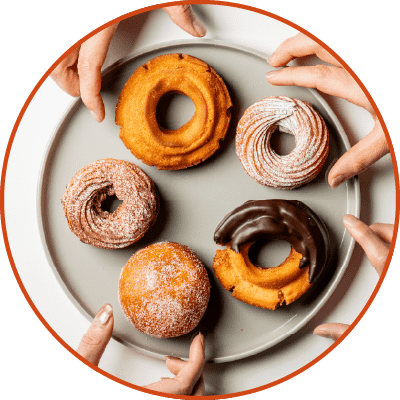 大きなお皿の上に並べられたドーナツを手に取る様子
